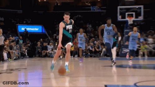 A Basketball Player With The Number 21 On His Jersey Dribbles The Ball GIF