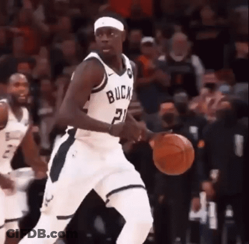 A Basketball Player With The Number 21 On His Jersey Is Dribbling A Basketball During A Game . GIF