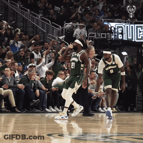 A Basketball Player With The Number 21 On His Jersey Is Running On The Court GIF