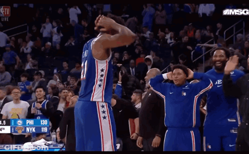 A Basketball Player With The Number 21 On His Jersey Stands In Front Of A Crowd GIF