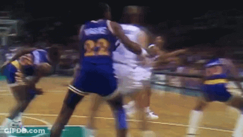A Basketball Player With The Number 22 On His Jersey Is Being Fouled By Another Player GIF
