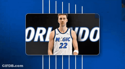 A Basketball Player With The Number 22 On His Jersey Stands In Front Of A Blue Background GIF