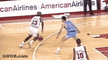 A Basketball Player With The Number 23 On His Jersey Dribbles The Ball GIF