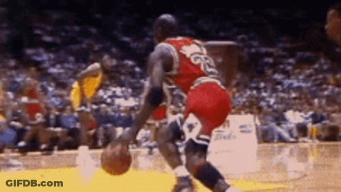 A Basketball Player With The Number 23 On His Jersey Is Dribbling A Basketball GIF