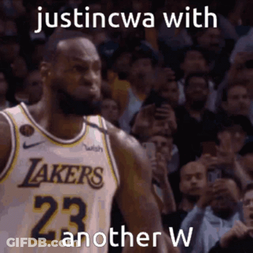 A Basketball Player With The Number 23 On His Jersey Is Standing In Front Of A Crowd . GIF