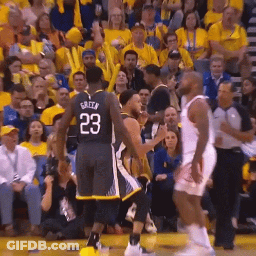 A Basketball Player With The Number 23 On His Jersey Is Talking To Another Player On The Court . GIF