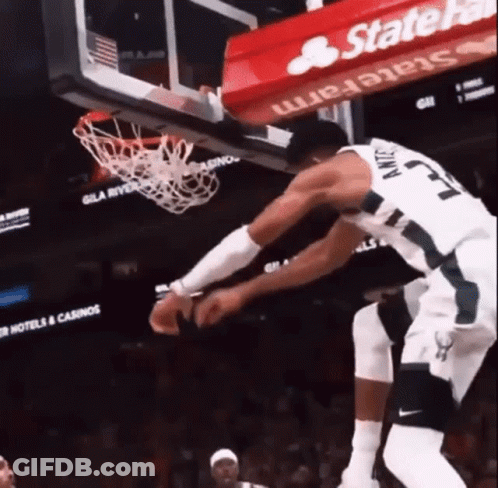 A Basketball Player With The Number 23 On His Jersey Jumps Into The Net GIF