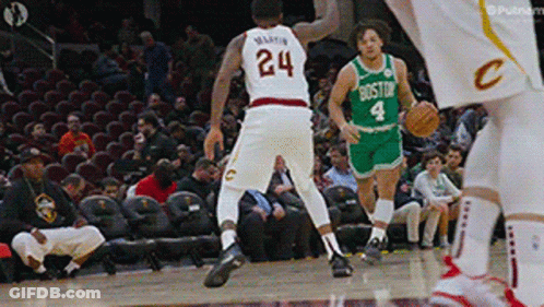 A Basketball Player With The Number 24 On His Jersey Dribbles The Ball GIF
