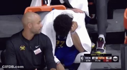 A Basketball Player With The Number 27 On His Jersey Is Sitting On The Bench GIF