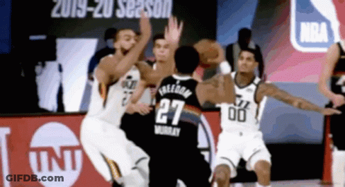 A Basketball Player With The Number 27 On His Jersey Tries To Get The Ball GIF