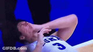 A Basketball Player With The Number 3 On His Jersey Is Laying On The Floor With His Head In His Hands . GIF