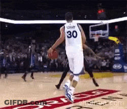 A Basketball Player With The Number 30 On His Jersey Is Jumping Over Another Player GIF