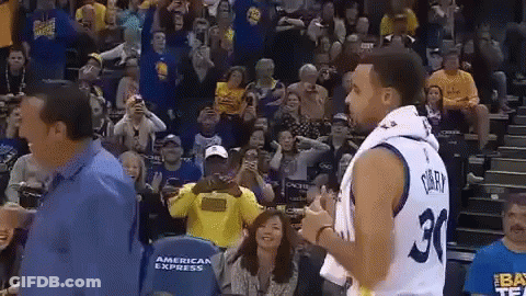 A Basketball Player With The Number 30 On His Jersey Is Standing In Front Of A Crowd Of People . GIF