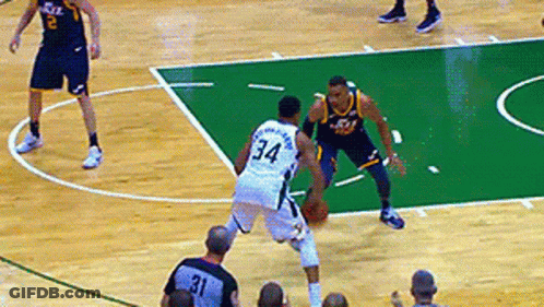 A Basketball Player With The Number 34 On His Back Dribbles The Ball GIF