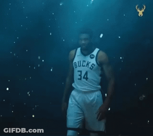A Basketball Player With The Number 34 On His Jersey Is Standing In Front Of A Green Ball . GIF