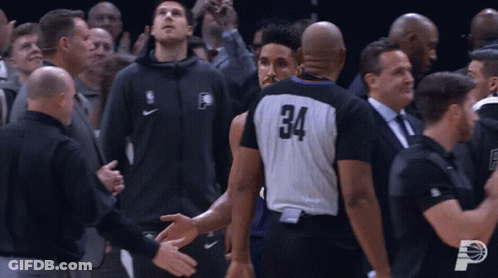 A Basketball Player With The Number 34 On His Jersey Shakes Hands With A Referee GIF