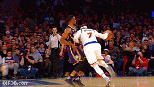 A Basketball Player With The Number 7 On His Jersey Is Playing Against Another Player GIF