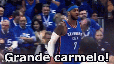 A Basketball Player With The Number 7 On His Jersey Stands In Front Of A Crowd And Says Grande Carmelo ! GIF