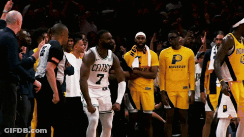 A Basketball Player With The Number 7 On His Jersey Stands In Front Of His Teammates GIF