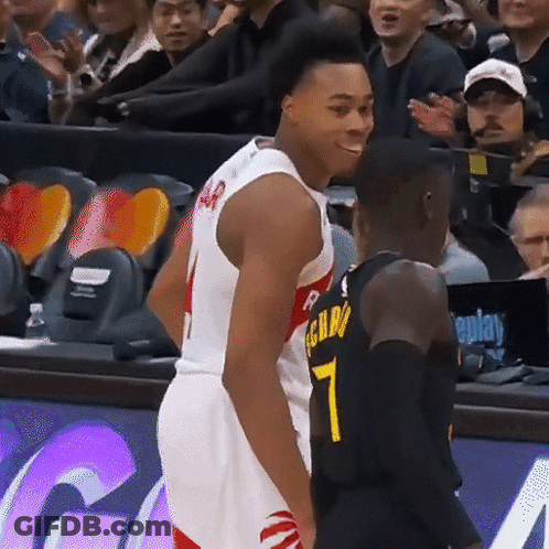 A Basketball Player With The Number 7 On His Jersey Stands Next To Another Player GIF