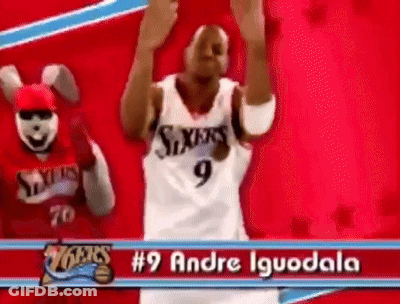 A Basketball Player With The Number 9 On His Jersey Is Dancing In Front Of A Mascot . GIF