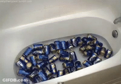 A Bathtub Filled With Cans Of Miller Lite GIF