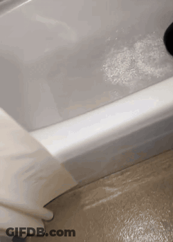 A Bathtub With A Lot Of Foam On The Floor GIF