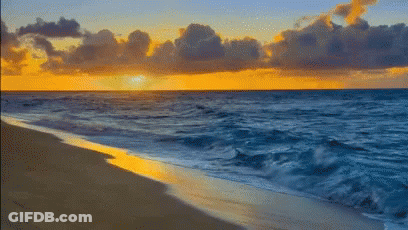 A Beach With A Sunset In The Background And Waves Crashing On The Sand GIF