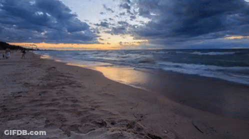 A Beach With A Sunset In The Background GIF
