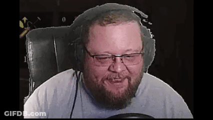 A Bearded Man Wearing Headphones And Glasses Is Sitting In A Chair . GIF