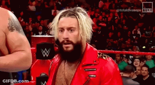 A Bearded Wrestler In A Red Jacket Is Standing In A Ring . GIF