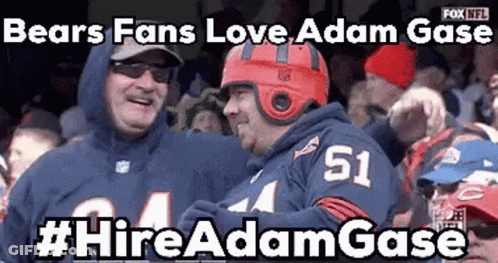 A Bears Fan Wearing A Red Helmet Is Standing Next To Another Fan Wearing A Number 51 Jersey . GIF