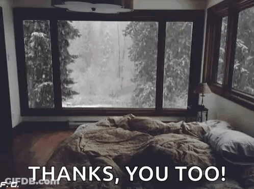 A Bed In A Bedroom With A Large Window Looking Out To A Forest . GIF