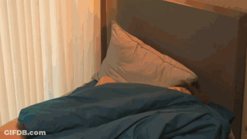 A Bed With A Blue Blanket And A Pillow On It GIF