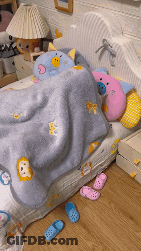 A Bed With A Blue Blanket With A Lion On It GIF