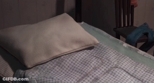 A Bed With A White Pillow And A Blue Blanket GIF