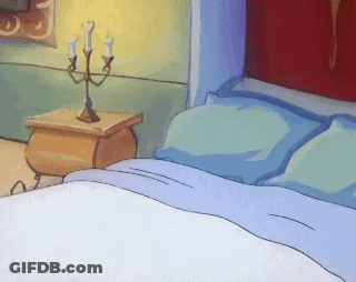 A Bed With Blue Sheets And A Nightstand With Candles GIF
