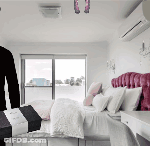 A Bedroom With A Bed And A Person Holding A Box With A Label That Says ' Abercrombie & Fitch ' GIF