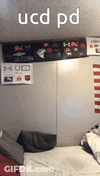 A Bedroom With A Bed And A Sign That Says Ucd Pd On It GIF