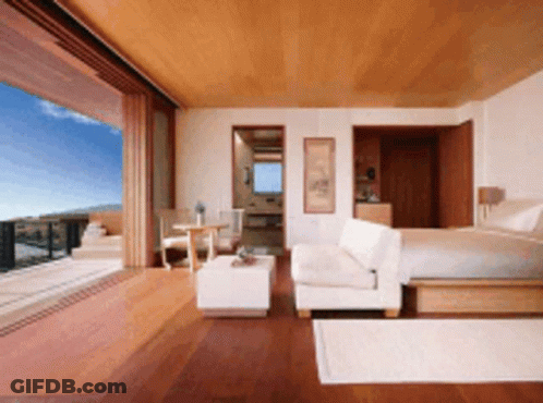 A Bedroom With A King Size Bed And A Couch GIF