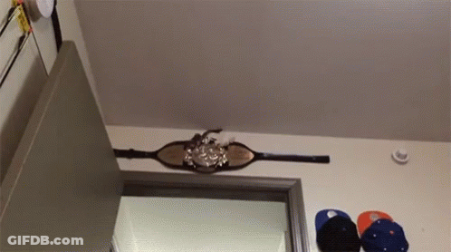 A Belt Is Hanging From The Ceiling In A Room With Hats Hanging On The Wall GIF