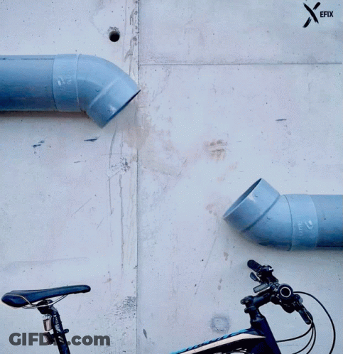 A Bicycle Is Parked Next To A Wall With Pipes And A Sticker That Says Efix GIF