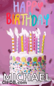 A Birthday Cake With Candles And Confetti On It And The Name Michael On It . GIF