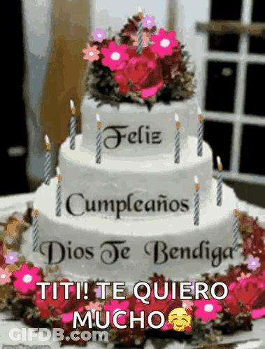 A Birthday Cake With Candles And Flowers On Top Of It GIF