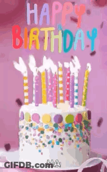 A Birthday Cake With Candles And Sprinkles On It And The Words `` Happy Birthday '' Written On It . GIF