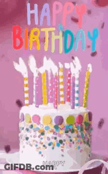 A Birthday Cake With Candles And Sprinkles On It Is On A Plate . GIF