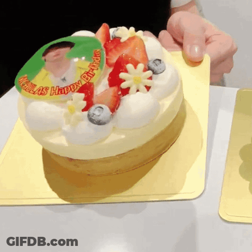A Birthday Cake With Strawberries And Blueberries And The Words Nicolas Happy Birthday GIF
