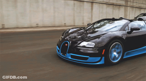 A Black And Blue Sports Car Is Driving Down A Street GIF