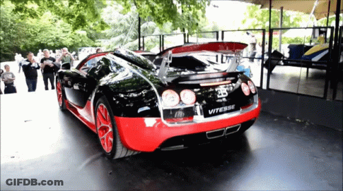 A Black And Red Bugatti Vitesse Is Parked In Front Of A Crowd Of People GIF