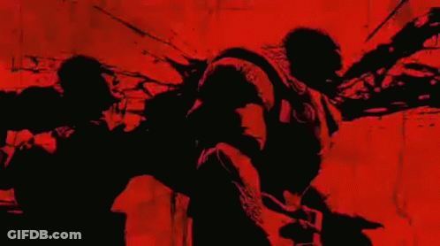 A Black And Red Silhouette Of A Person Standing In Front Of A Red Wall . GIF